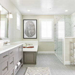 Corner shower - transitional white tile gray floor corner shower idea in San Francisco with recessed-panel cabinets, gray cabinets, an undermount tub, beige walls, an undermount sink, a hinged shower door and white countertops