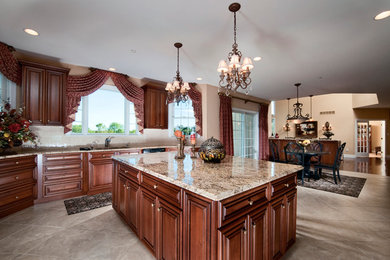 Open concept kitchen - mid-sized traditional u-shaped porcelain tile and beige floor open concept kitchen idea in Philadelphia with an undermount sink, raised-panel cabinets, dark wood cabinets, granite countertops, beige backsplash, porcelain backsplash, black appliances and an island