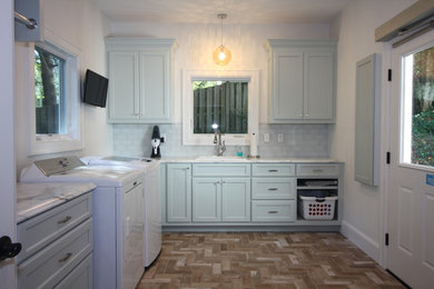 Laundry room - transitional l-shaped ceramic tile laundry room idea in Other with an undermount sink, recessed-panel cabinets, quartz countertops, white walls and a side-by-side washer/dryer