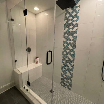Beautiful bathroom with vertical 12x24 white tiles and a scallop waterfall.