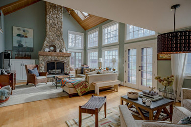 Living room - large farmhouse open concept and formal light wood floor and brown floor living room idea in Boston with green walls, a wood stove, a stone fireplace and no tv