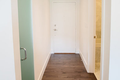 Inspiration for a contemporary dark wood floor entryway remodel in Calgary with white walls and a white front door