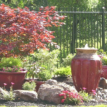Asian red pot fountain and pots with Japanese maple