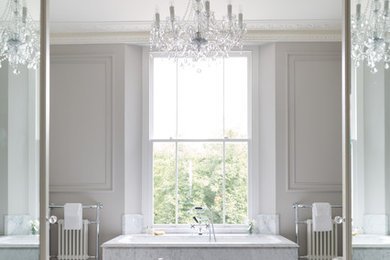 Design ideas for a classic ensuite bathroom in London with a built-in bath and marble flooring.