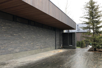 Ejemplo de fachada de casa gris y gris actual grande de dos plantas con tejado de varios materiales y tablilla