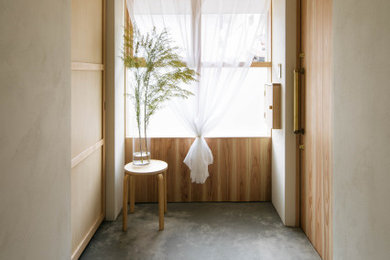 名古屋にあるモダンスタイルのおしゃれな玄関 (ベージュの壁、コンクリートの床、グレーの床、塗装板張りの天井、羽目板の壁、ベージュの天井、木目調のドア) の写真