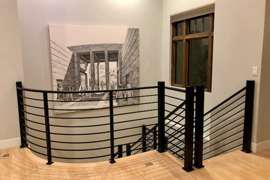 Example of a mid-sized minimalist curved metal railing staircase design in Denver