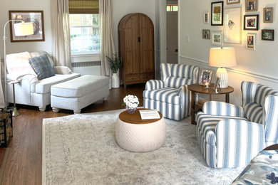 Example of a mid-sized transitional medium tone wood floor and brown floor living room design in Baltimore with white walls, a wood stove and a tile fireplace