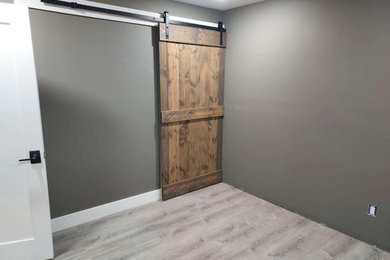 Basement - large traditional underground vinyl floor and gray floor basement idea in Grand Rapids with gray walls