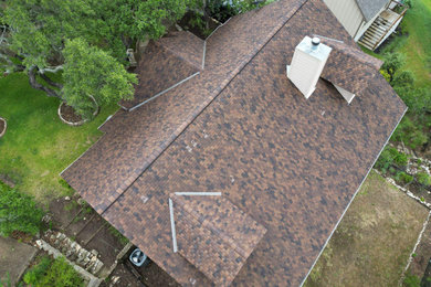 Mid-sized minimalist two-story exterior home photo in Austin with a shingle roof and a brown roof