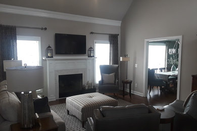 Foto de sala de estar abierta contemporánea grande con paredes grises, suelo de madera oscura, todas las chimeneas, marco de chimenea de baldosas y/o azulejos y suelo marrón