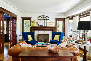 Inspiration for a mid-sized eclectic formal enclosed living room in Portland with white walls, medium hardwood floors, a standard fireplace and a stone fireplace surround.
