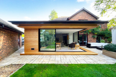 Diseño de fachada de casa gris contemporánea de tamaño medio con revestimiento de madera, tejado a cuatro aguas, tejado de metal y panel y listón