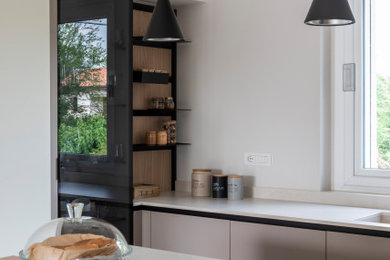 Ispirazione per una cucina contemporanea di medie dimensioni con ante lisce, ante beige, elettrodomestici neri, pavimento in gres porcellanato e pavimento marrone