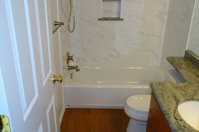 Bathroom - small transitional master white tile and porcelain tile vinyl floor and brown floor bathroom idea in Oklahoma City with shaker cabinets, medium tone wood cabinets, a two-piece toilet, white walls, an undermount sink and granite countertops