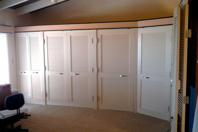 This is an example of a mid-sized tropical storage and wardrobe in San Diego with carpet.