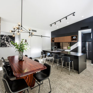 Large modern kitchen pantry ideas - Kitchen pantry - large modern single-wall kitchen pantry idea in Townsville with flat-panel cabinets, black cabinets, granite countertops, metallic backsplash, mirror backsplash, an island and multicolored countertops