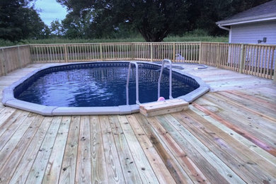 Inspiration for a mid-sized timeless backyard aboveground pool remodel in Houston with decking