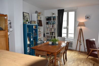 Photo of a mid-sized midcentury dining room in Paris with white walls and light hardwood floors.