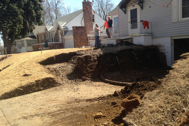 Photo of a traditional front yard driveway for spring in Omaha with a retaining wall.