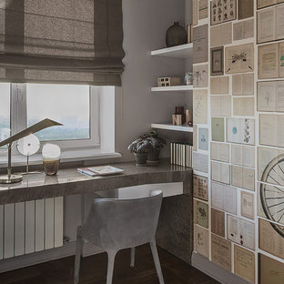 Неиссякаемый источник вдохновения для домашнего уюта: рабочее место в современном стиле с серыми стенами, темным паркетным полом, встроенным рабочим столом и коричневым полом