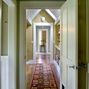 Foto på en lantlig hall, med gröna väggar och mellanmörkt trägolv