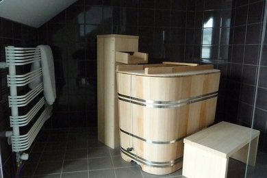Aménagement d'une petite salle de bain moderne avec un bain japonais, un carrelage noir, des carreaux de céramique, un mur noir et un sol en carrelage de porcelaine.