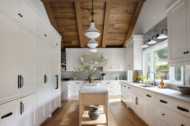Inspiration for a rustic vaulted ceiling kitchen remodel in San Francisco with shaker cabinets, subway tile backsplash and an island