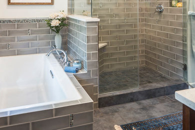 This is an example of a mid-sized transitional master bathroom in Chicago with shaker cabinets, dark wood cabinets, an alcove tub, an alcove shower, a one-piece toilet, gray tile, subway tile, white walls, slate floors, an undermount sink and engineered quartz benchtops.