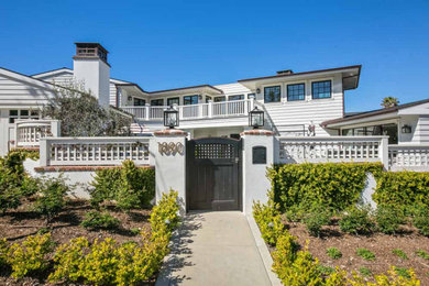 Example of a beach style white two-story house exterior design in San Diego