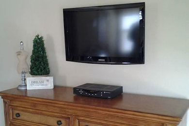 Inspiration for a timeless living room remodel in Dallas with white walls and a wall-mounted tv