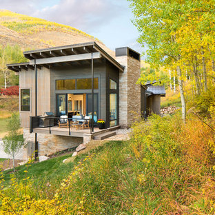 Bild på ett mellanstort funkis brunt hus, med två våningar, blandad fasad och pulpettak