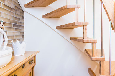 Gewendelte, Kleine Moderne Treppe mit gebeizten Holz-Setzstufen und Mix-Geländer in Sonstige