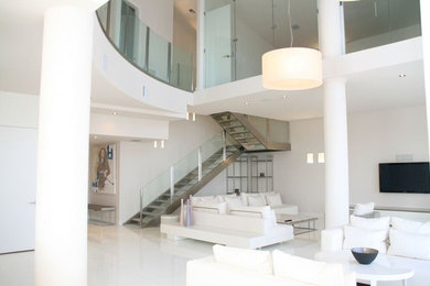 Inspiration for a large contemporary open concept white floor family room remodel in Miami with white walls, no fireplace and a wall-mounted tv