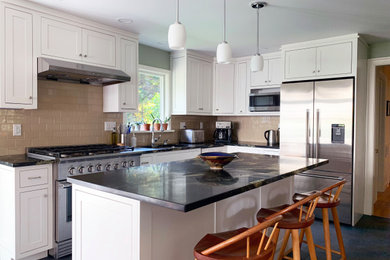 Inspiration for a mid-sized timeless l-shaped slate floor and black floor open concept kitchen remodel in Boston with an undermount sink, recessed-panel cabinets, white cabinets, granite countertops, brown backsplash, subway tile backsplash, stainless steel appliances, an island and black countertops