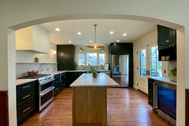 Inspiration for a mid-sized modern l-shaped medium tone wood floor and brown floor open concept kitchen remodel in Oklahoma City with an undermount sink, shaker cabinets, green cabinets, quartz countertops, white backsplash, quartz backsplash, stainless steel appliances, an island and white countertops