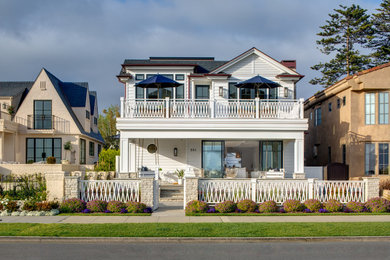 Example of a large beach style white two-story mixed siding exterior home design in San Diego with a shingle roof and a black roof