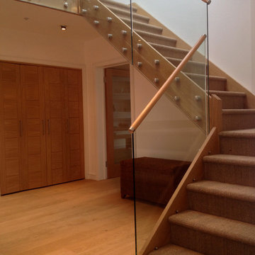 Bungalow oak and glass staircase with natural sea grass on treads