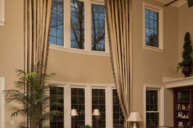 Example of a large classic open concept medium tone wood floor and red floor family room design in Raleigh with beige walls