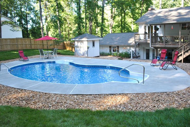 Mid-sized traditional backyard kidney-shaped pool in DC Metro with concrete slab.
