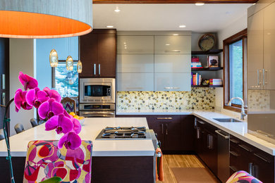 Large trendy galley medium tone wood floor open concept kitchen photo in Salt Lake City with an undermount sink, flat-panel cabinets, dark wood cabinets, multicolored backsplash, stainless steel appliances and an island