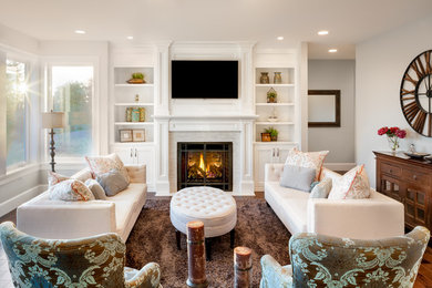 Photo of a large traditional open concept family room in Boston with white walls, light hardwood floors, a standard fireplace and a wall-mounted tv.