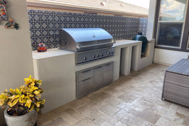 Example of a large southwest backyard stone patio kitchen design in Phoenix with a roof extension