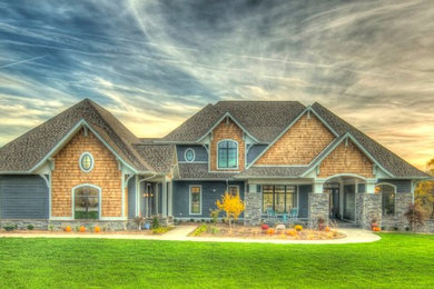 Example of a huge transitional blue two-story wood house exterior design in Cedar Rapids with a hip roof and a shingle roof