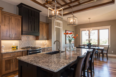 Mid-sized transitional single-wall dark wood floor and brown floor open concept kitchen photo in Wichita with an undermount sink, shaker cabinets, medium tone wood cabinets, granite countertops, beige backsplash, an island and beige countertops