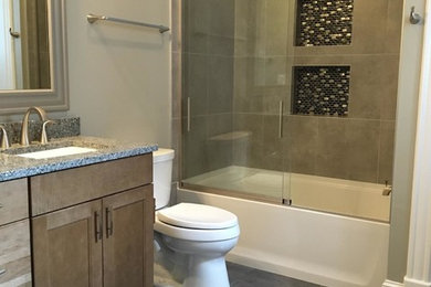 Inspiration pour une salle de bain traditionnelle en bois brun de taille moyenne pour enfant avec un placard à porte shaker, une baignoire en alcôve, un combiné douche/baignoire, WC séparés, un carrelage beige, un carrelage gris, un carrelage de pierre, un mur gris, un sol en ardoise, un lavabo encastré et un plan de toilette en granite.
