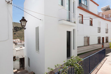 Diseño de fachada de casa blanca contemporánea de tamaño medio de tres plantas con revestimiento de aglomerado de cemento, tejado plano y tejado de varios materiales