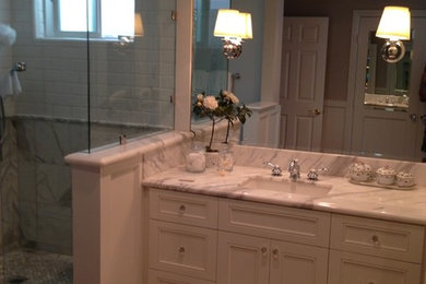 Example of a mid-sized transitional master gray tile and marble tile dark wood floor and brown floor alcove shower design in Orange County with beaded inset cabinets, white cabinets, gray walls, an undermount sink, marble countertops, a hinged shower door and gray countertops