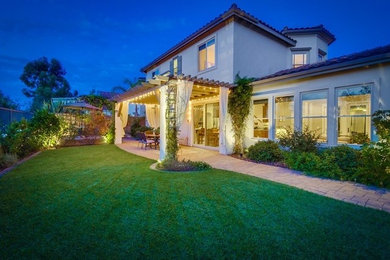 Photo of a mid-sized mediterranean partial sun backyard brick landscaping in San Diego for summer.