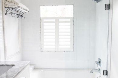 Small elegant white tile and ceramic tile marble floor bathroom photo in Atlanta with an undermount sink, flat-panel cabinets, white cabinets, marble countertops, a two-piece toilet and white walls